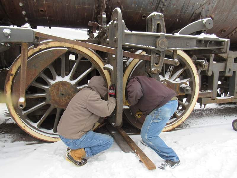 Charley Sedgley and Rich Kulik work outside in the cold to remove parts of the brake rigging on 4070