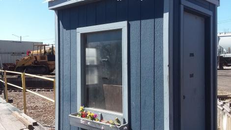 The plastic flowers are blooming in the flower box of the turntable control hut